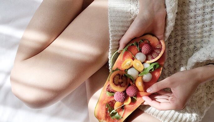 Chica con papaya y otras frutas.